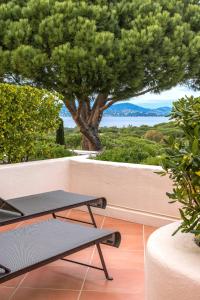 a balcony with two tables and a tree at Ch&acirc;teau de la Messardi&egrave;re in Saint-Tropez