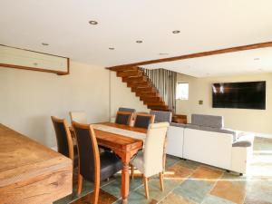 a dining room with a wooden table and chairs at Green Barn in Sheffield