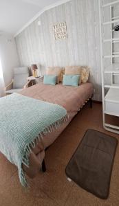 a bedroom with a bed with a green blanket at Casa Faroleiro in Nazaré