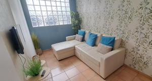 a living room with a couch and a tv at Casa Faroleiro in Nazaré