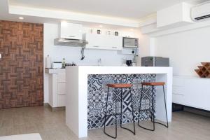 uma cozinha com um balcão e dois bancos em Ocean front Villa Marlin, best location in hotel zone #109 em Cancún