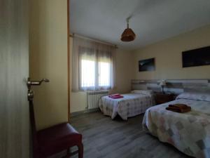 a hotel room with two beds and a window at Casa Rural Santa Bárbara in El Real de San Vicente
