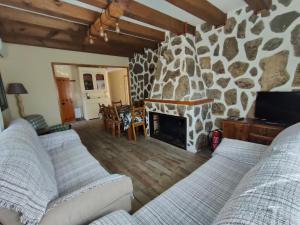 a living room with two couches and a stone fireplace at Casa Rural Santa Bárbara in El Real de San Vicente