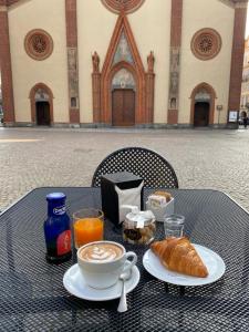 皮內羅洛的住宿－Domus Acaja，一张桌子,上面放着一杯咖啡和一盘羊角面包