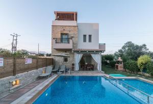 a villa with a swimming pool and a house at Villa Eleni in Pitsidia