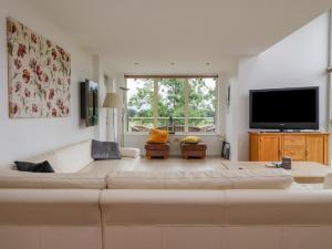 sala de estar con sofá grande y TV de pantalla plana en 7 The Meadows, en Carnforth