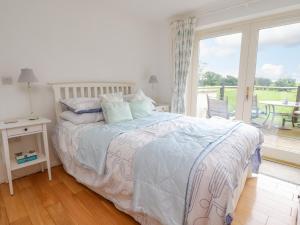 a bedroom with a bed and a large window at 7 The Meadows in Carnforth