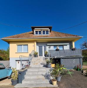a yellow house with a staircase in front of it at Villa Beau Site in Saint-Maurice