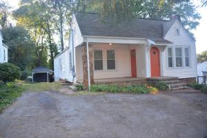 una pequeña casa blanca con una puerta roja en Grateful GVL Gathering III, en Greenville