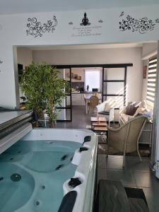 a bath tub in a room with a living room at Villa Beau Site in Saint-Maurice