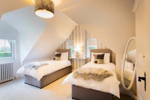 a attic bedroom with two beds and a staircase at Stunning 4 bedroom country house - Hot Tub & Sauna in Glasgow