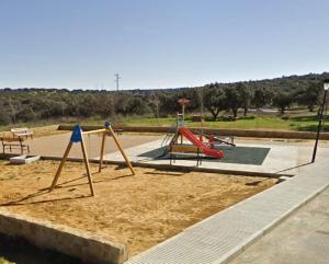 un parque con un parque infantil con un tobogán en la arena en LA GINETA, 