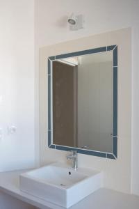 a bathroom with a white sink and a mirror at Les Maisons de l'Olivette in La Couarde-sur-Mer