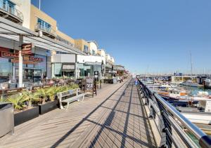a boardwalk next to a marina with boats at Orion in Brighton & Hove
