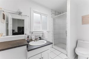 a white bathroom with a sink and a shower at 18th Street E in Boise