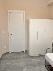 ein Zimmer mit zwei weißen Schränken und einer Tür in der Unterkunft La Piazzetta in Olivarella