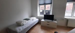 1 dormitorio con 1 cama y mesa con TV en Private Room in a shared apartment, en Odense