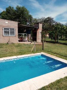 a swimming pool in front of a house at Cabaña La Calandria in San José del Rincón