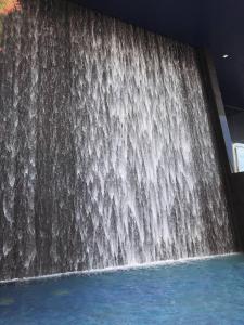 a waterfall in the middle of a pool of water at Kariris Blue Tower in Crato