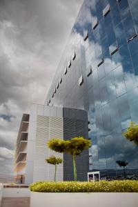 a glass building with trees in front of it at Kariris Blue Tower in Crato