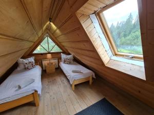 Cette chambre mansardée comprend 2 lits et 2 fenêtres. dans l'établissement GliczarowSki u Zbója, à Zakopane