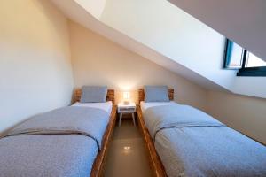 a attic bedroom with two beds and a table at Apartamento Cabra Playa de Langosteira en Finisterre con vistas al mar in San Martín de Arriba