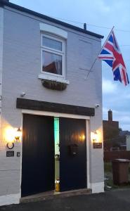 a house with a flag flying in front of it at Stable cottage cozy,quirky with a hot tub in Bridlington