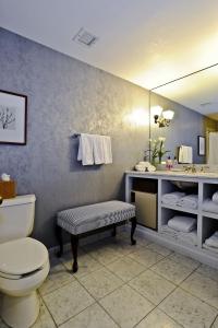 a bathroom with a toilet and a sink and a mirror at The Simsbury Inn in Simsbury