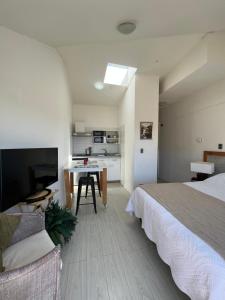 1 dormitorio con cama, mesa y cocina en Hermoso departamento en cerro Bellavista, en Valparaíso