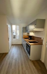 a kitchen with wooden floors and stainless steel appliances at Appartement Centre ville Le Havre in Le Havre