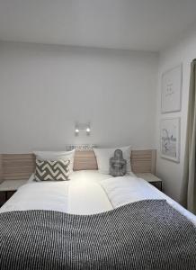 a bedroom with a large bed with a black and white blanket at Lieblingsplatz Neusiedl Appartement - Erhol dich gut in Neusiedl am See