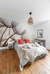 ein Schlafzimmer mit einem großen Bett und roten Kissen in der Unterkunft Résidence Epinat - Appartements centre & parking in Vichy