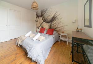 ein Schlafzimmer mit einem Bett mit roten Kissen in der Unterkunft Résidence Epinat - Appartements centre & parking in Vichy + 82 Fotos
