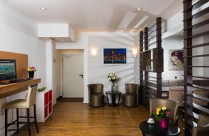 a living room with a table and chairs and a counter at Leonardo Hotel Frankfurt City Center in Frankfurt/Main