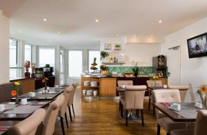 a restaurant with tables and chairs and a counter at Leonardo Hotel Frankfurt City Center in Frankfurt