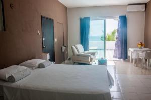 ein Schlafzimmer mit einem Bett, einem Stuhl und einem Fenster in der Unterkunft CANCUN PRIVATE APARTMENT in Cancún