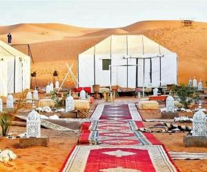 una tenda nel deserto con tappeto rosso di Sahara Luxury Tented Camp a Merzouga