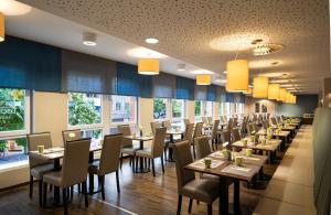 une rangée de tables et de chaises dans un restaurant dans l'établissement Leonardo Hotel Berlin, à Berlin