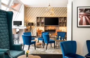 a lobby with blue chairs and a living room at Leonardo Hotel Berlin in Berlin