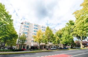 een gebouw aan de zijkant van een straat met bomen bij Leonardo Hotel Düsseldorf City Center in Düsseldorf