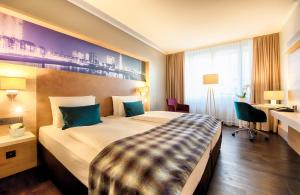 杜塞道夫的住宿－杜塞爾多夫國王大道萊昂納多皇家酒店，酒店客房设有一张大床和一张书桌。