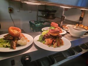 trois assiettes de nourriture sur un comptoir dans une cuisine dans l'établissement Jubilee pub, à Litherland