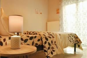 ein Wohnzimmer mit einem Sofa und einem Tisch mit einer Lampe in der Unterkunft TasoulasHome 1-μονοκατοικια με αυλη in Komotiní