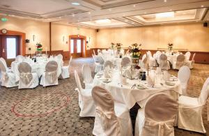 a banquet hall with white tables and chairs at Leonardo Hotel Düsseldorf Airport Ratingen in Ratingen