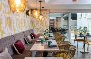 um restaurante com mesas e cadeiras de madeira e um sofá em Leonardo Boutique Hotel Rome Termini em Roma