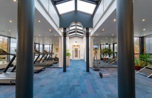 einen Fitnessraum mit Laufbändern und Pilates-Geräten in der Unterkunft Leonardo Hotel Frankfurt City South in Frankfurt am Main