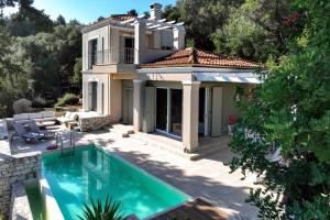 a villa with a swimming pool and a house at Apeiron I Villa by PaxosRetreats in Oziás