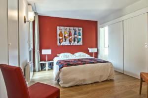 um quarto vermelho com uma cama e uma parede vermelha em Résidence Quai Sud-Le Cartier em Saint Malo