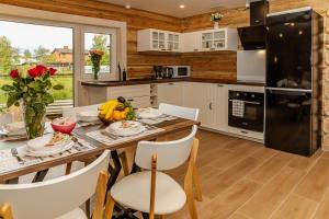 a kitchen and dining room with a table and chairs at Villa Rose & SPA in Mežciems