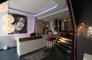 a bar in a restaurant with purple lighting at Leonardo Boutique Hotel Munich in Munich